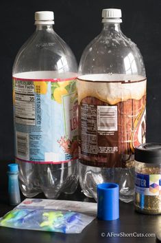 two water bottles sitting next to each other on top of a table with craft supplies