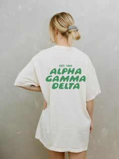 Soft, cute, and trendy, this Alpha Gamma Delta sorority t-shirt will quickly become your go-to cozy shirt! Use the drop down to specify preference between white, ivory, chambray, orchid, or blossom. LISTING IS FOR ALPHA GAM. Please be sure you are ordering for your correct Sorority. We print on high quality, soft, & heavyweight materials, sustainably made and printed in the US. ♥ SIZING ♥ Unisex Sizing- For a more feminine, fitted look we recommend getting your size. For a more oversized look, w Cheap Sorority Summer T-shirt, Oversized School Spirit T-shirt With Letter Print, White Sorority Graphic Print T-shirt, Sorority Cotton T-shirt With Graphic Print, White Sorority Tops With Letter Print, White School Spirit T-shirt For Everyday, Sorority Crew Neck Top For Streetwear, White Crew Neck Sorority T-shirt, Pre-shrunk Crew Neck Sorority T-shirt