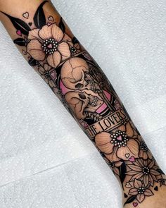 a woman's leg with flowers and skulls on it