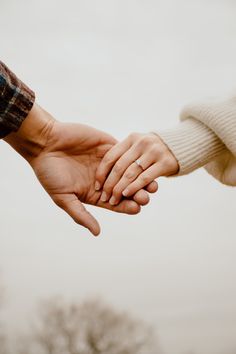 two people are holding hands with each other