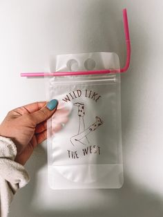 a person holding onto a clear bag with the words wild like the west printed on it