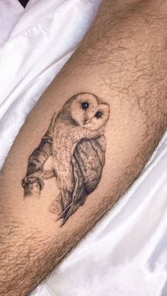 an owl tattoo on the leg of a man