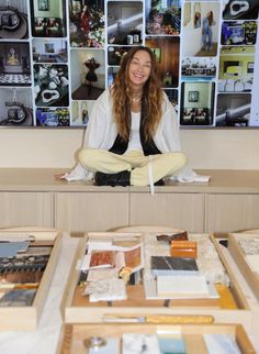 a woman sitting in front of a table with pictures on it