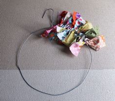 a piece of cloth is sitting on the floor next to a circle with some scissors