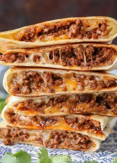 three burritos stacked on top of each other with meat and cheese in them