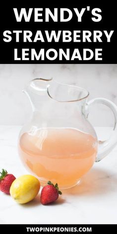 a pitcher of strawberry lemonade next to strawberries on a marble counter top with text overlay reading wendy's strawberry lemonade