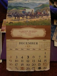 a calendar sitting on top of a table next to books and other items in a bin