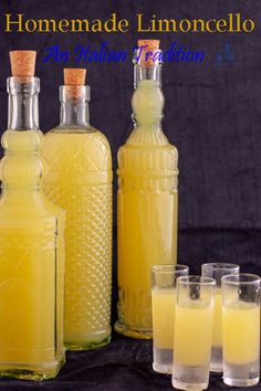 four bottles and glasses filled with lemonade sitting next to each other on a table