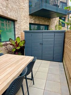 an outdoor table and chairs in front of a building