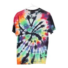 a tie - dyed shirt hanging on a hanger with the colors of rainbow and black