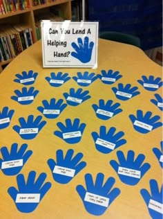 a table with blue handprints on it that says can you lead a helping hand?