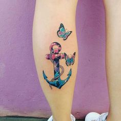 an anchor tattoo on the leg with butterflies around it and a snake wrapped around it