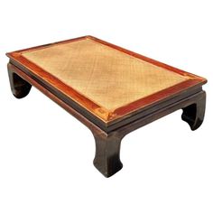 a coffee table with a wooden top and brown trimming on the bottom, sitting in front of a white background