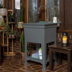 a bathroom sink sitting on top of a wooden table next to a potted plant