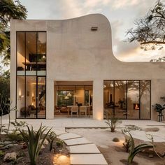 the exterior of a modern home with large windows and steps leading up to it's entrance