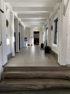 an empty hallway with white walls and wooden steps