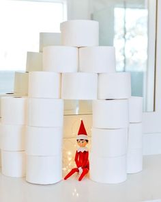 an elf is sitting in front of several rolls of toilet paper