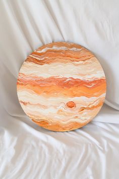 an orange and white plate sitting on top of a bed