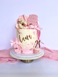 a pink and white birthday cake on a plate