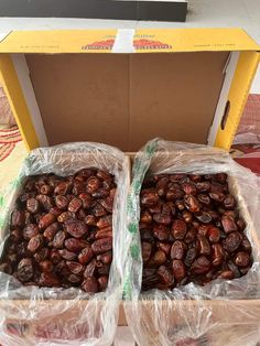 two boxes filled with nuts sitting on top of a table