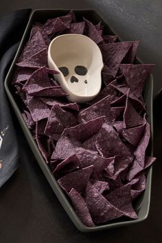 a bowl with chips and a skull face on it