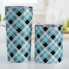 two blue and black plaid tumblers sitting next to each other on a white table