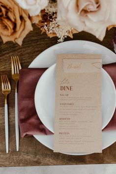 a place setting with napkins, silverware and flowers