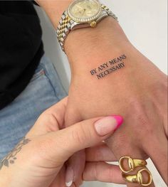 a woman's wrist with a tattoo saying by any means necessary