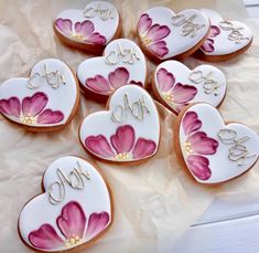 decorated cookies are arranged in the shape of hearts with initials and flowers painted on them