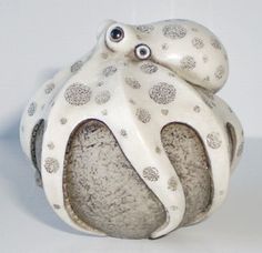 an octopus figurine sitting on top of a white surface with polka dot designs