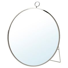 a round mirror sitting on top of a metal stand with a circular mirror hanging from it's side