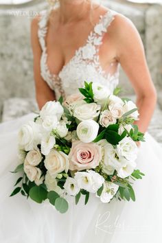 a bride holding a bouquet of white and pink flowers