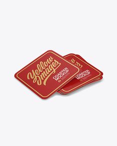 two red coasters with gold lettering on the front and back, sitting side by side