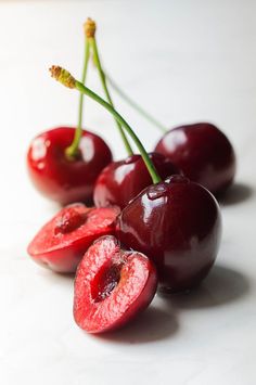 some cherries are sitting on a white surface