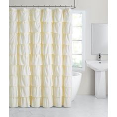 a bathroom with a white tub, sink and yellow shower curtain in front of a window