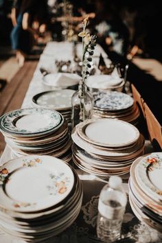 a long table with plates and vases on it