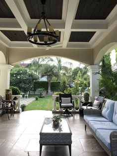 an outdoor living area with couches, tables and chairs