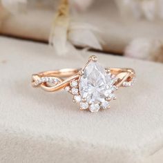 a white diamond ring sitting on top of a pillow