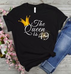 the queen is 50 t - shirt with gold crown on it and pink flowers next to it