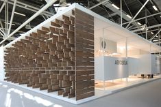 an exhibit booth with wooden panels on the wall and white walls in front of it