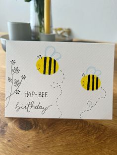 a card with two bees on it and the words happy bee birthday written in black ink