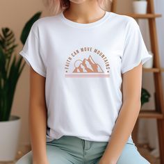 Embrace your faith with this Christian quote t-shirt. The shirt comes in white with short sleeves, and is made from 100% cotton with a regular fit.  The quote, "Faith Can Move Mountains" is prominently displayed on the front, reminding you to trust in a higher power and have hope for the future.  The shirt is available in sizes S-2XL and is perfect for anyone who want to express their faith in a stylish and comfortable way.  It is suitable for casual outings, church activities, or even as a gift White Inspirational Relaxed Fit T-shirt, Inspirational White Pre-shrunk T-shirt, Inspirational White Short Sleeve T-shirt, Christian Quotes Short, Faith Can Move Mountains, Christian Quote, Church Activities, Move Mountains, Women T Shirt