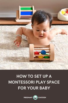 a baby laying on the floor playing with a wooden montessori play space for your baby