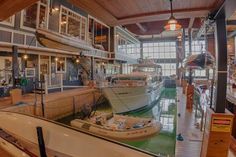 several boats are docked in the water inside a boathouse with many windows on each side