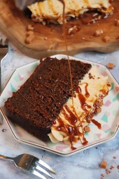 a piece of cake on a plate with ice cream and caramel drizzle