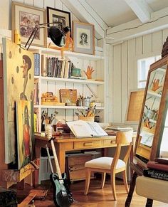 an artist's studio with lots of art on the walls and desks in it