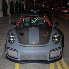 a grey and black sports car parked on the street