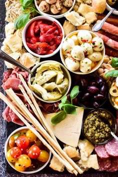 an assortment of different types of food on a platter with utensils and dips