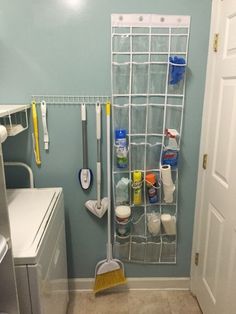 a bathroom with blue walls and flooring has a white rack on the wall holding cleaning supplies