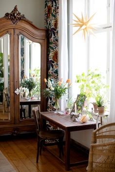 a living room filled with furniture and lots of plants on top of a wooden floor